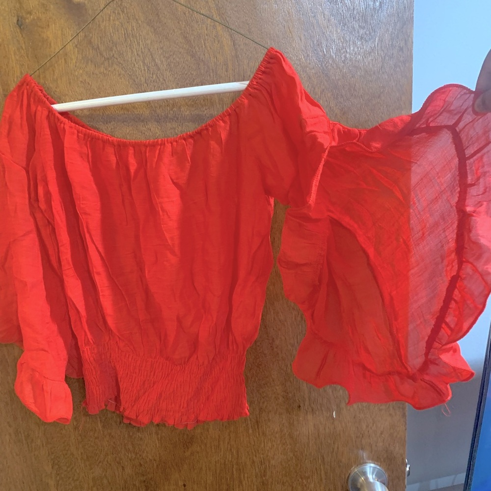 Red crop shirt. Flared arms. Never worn. I took the tag off thinking I’d wear it